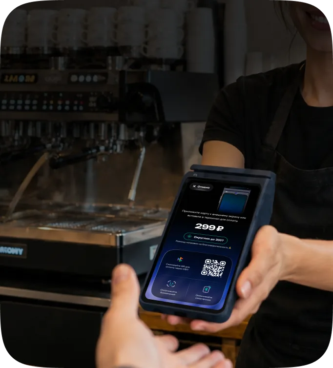 Продавец протягивает смарт-терминал с QR-кодом на оплату